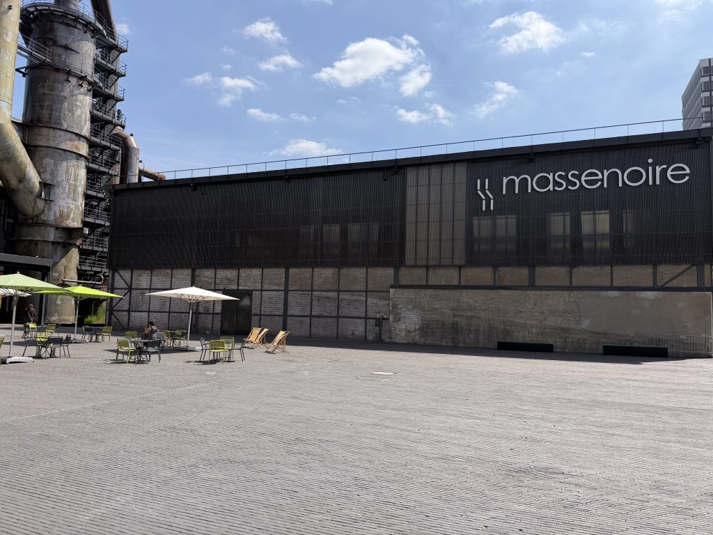 The Massenoire hall in Belval, with its sign along the front and the furnace structure beside it