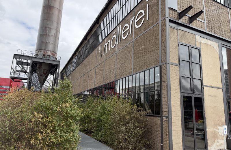 The Möllerei building in Belval, with its name along the facade and the chimney behind