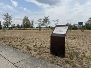 An information panel in Parc um Belval, with the open park ground behind