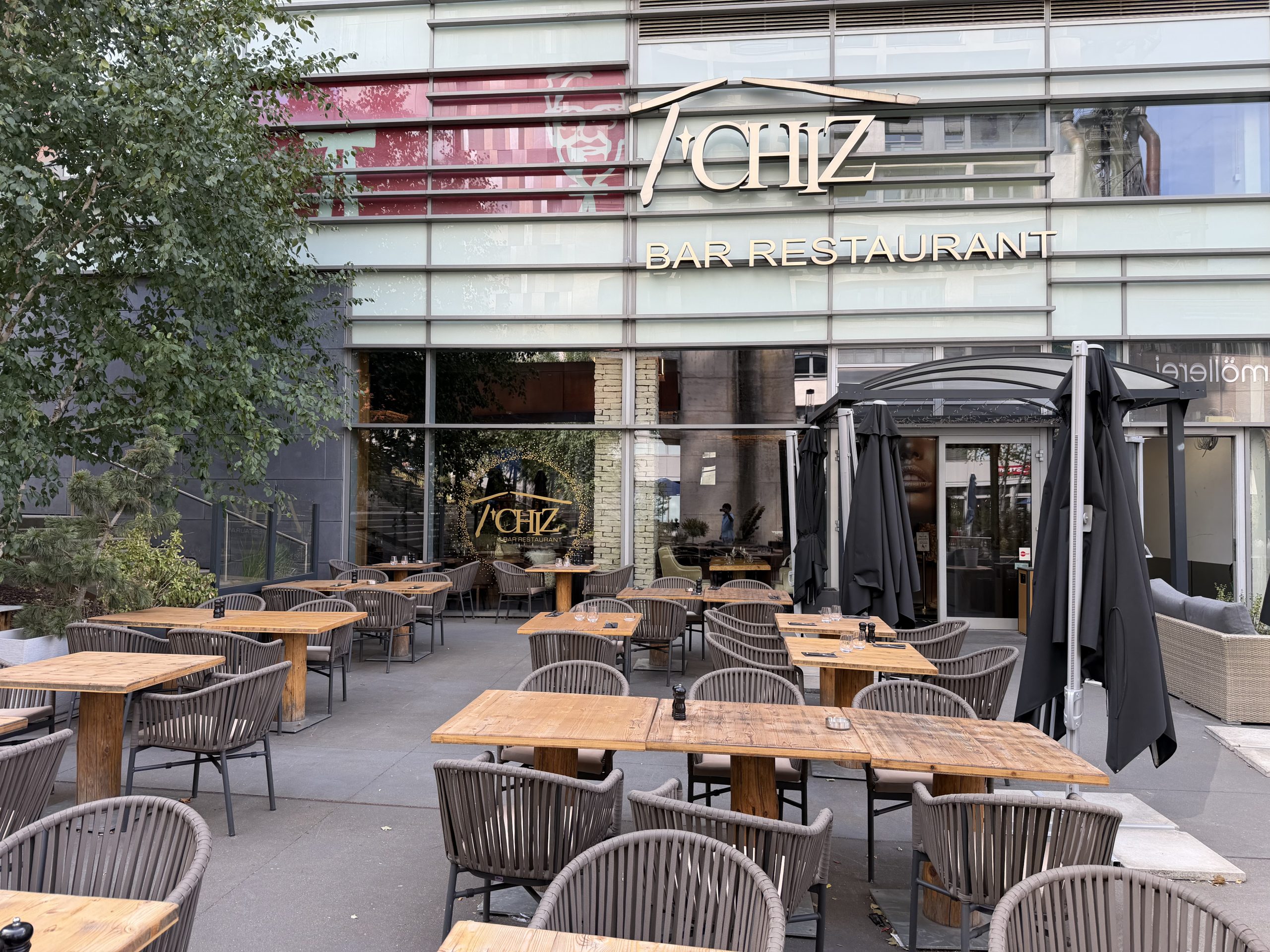 The Le T'Chiz terrace in Belval, with tables set out under the trees