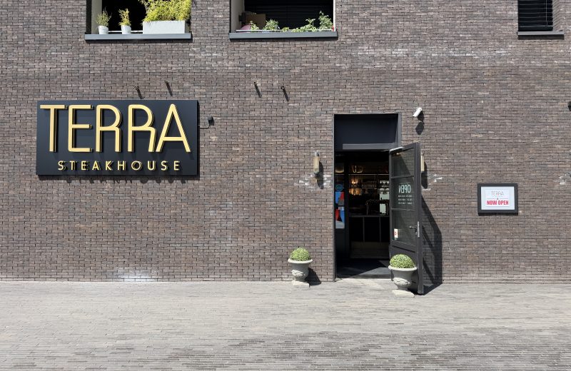 The Terra Steakhouse entrance in Belval, its sign on the brick facade