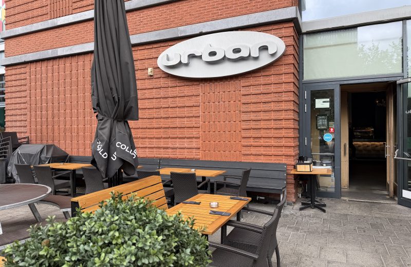 The Urban Belval terrace, with parasols and tables against the brick facade