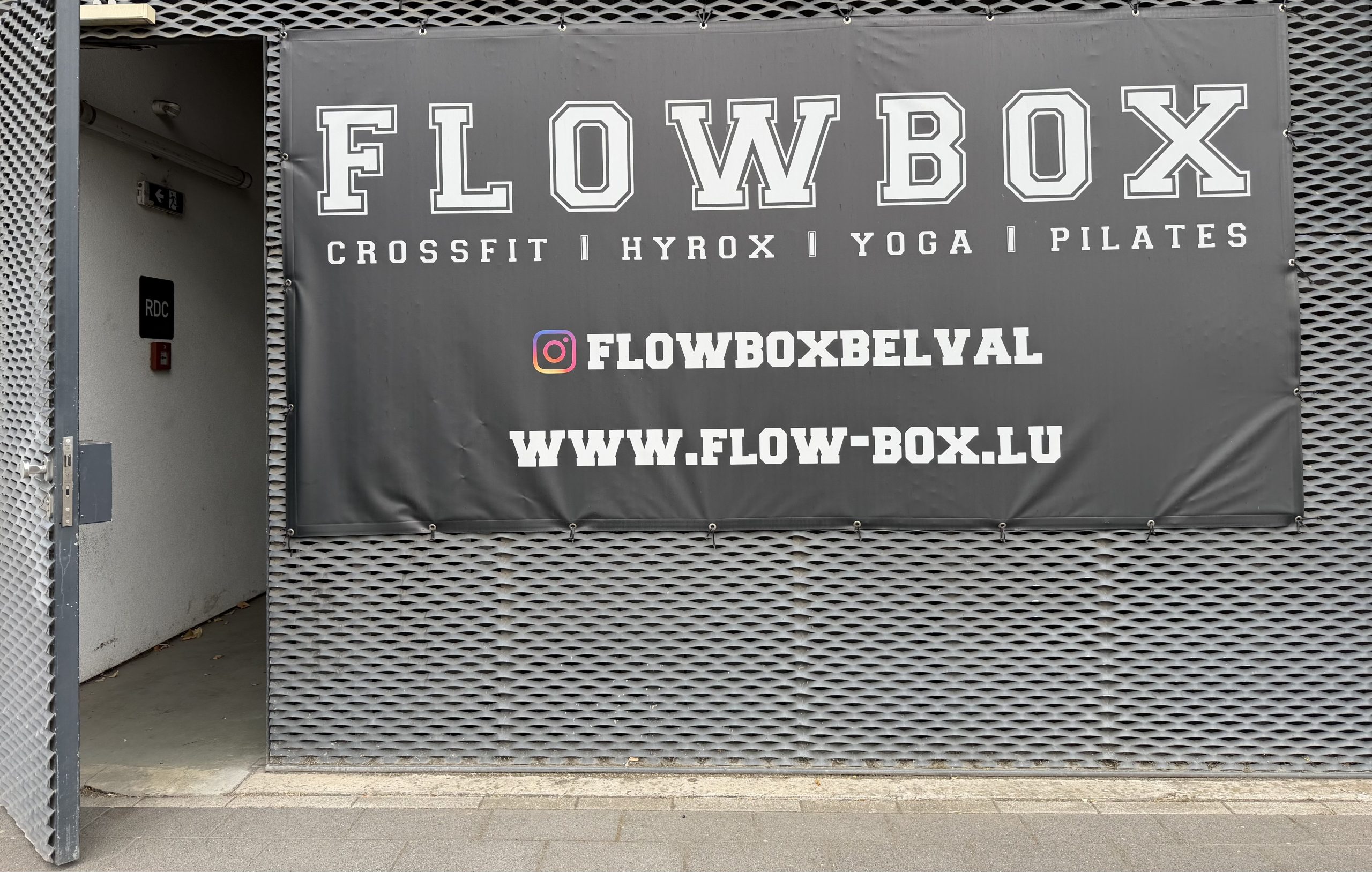 The FlowBox sign in Belval, listing CrossFit, Hyrox, yoga and Pilates