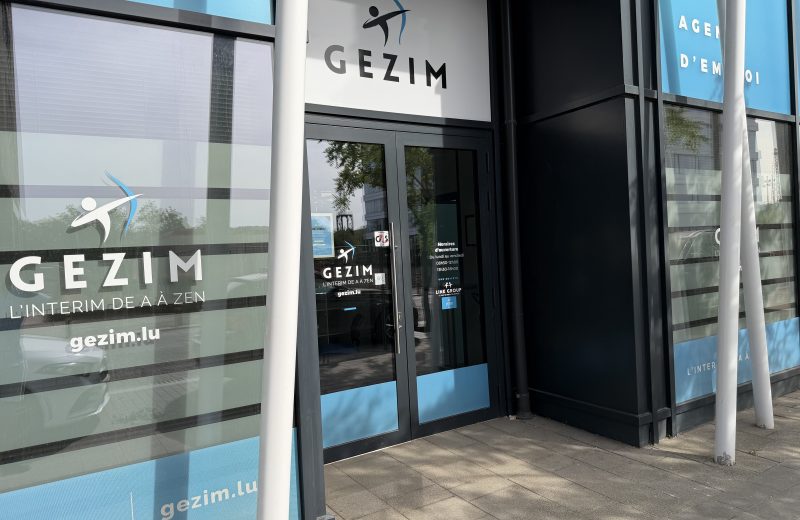 The GEZIM employment agency entrance in Belval, with the company name and the strapline l'intérim de A à Zen on the glass and opening hours on the door.
