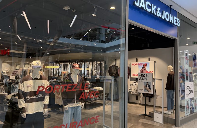 The Jack & Jones shopfront in Belval Plaza, with the blue Jack & Jones sign above the entrance and mannequins dressed in rugby shirts, denim jackets and caps in the window.