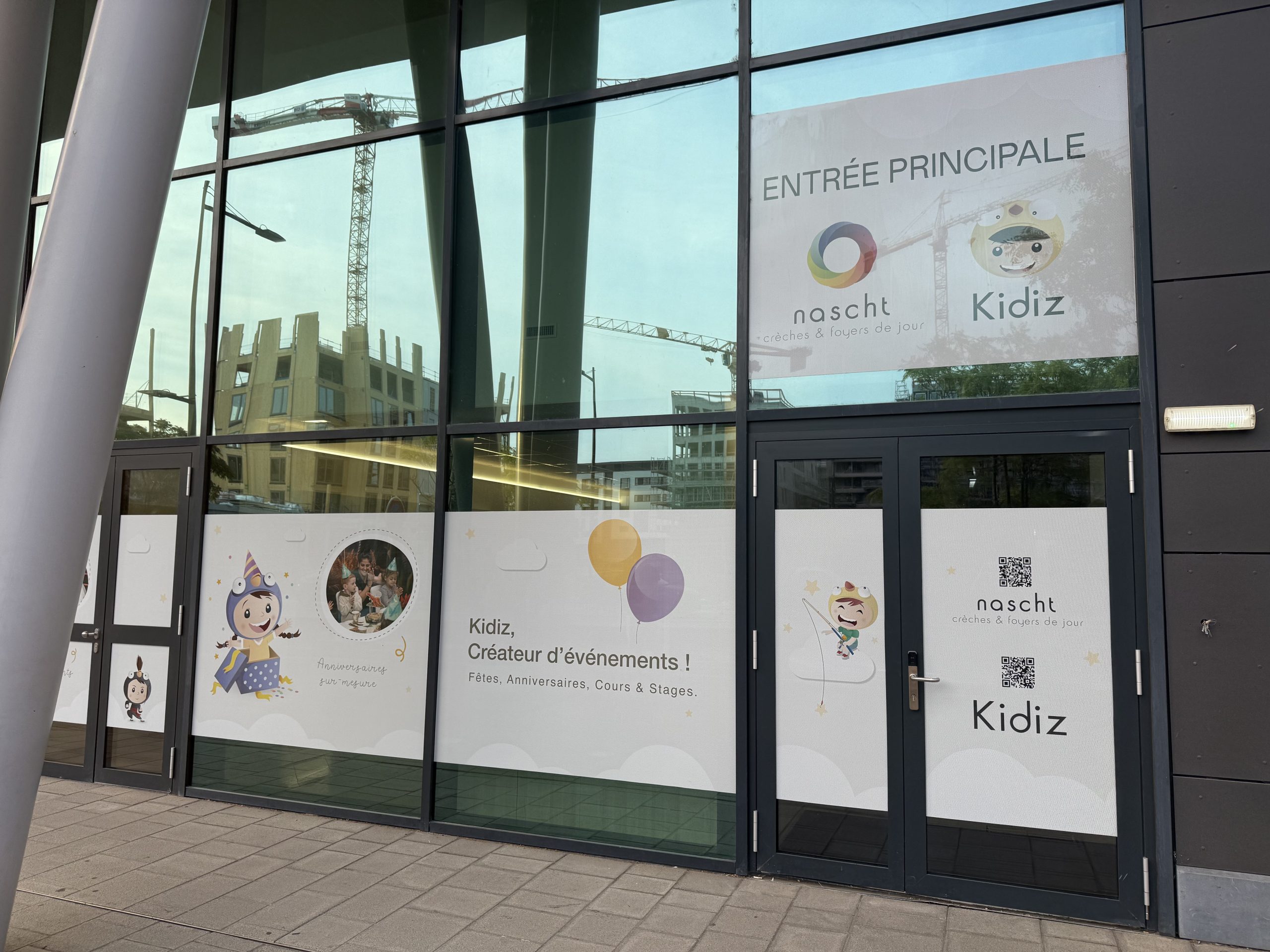The shared main entrance on Boulevard des Lumières in Belval, with Kidiz signed on the glass