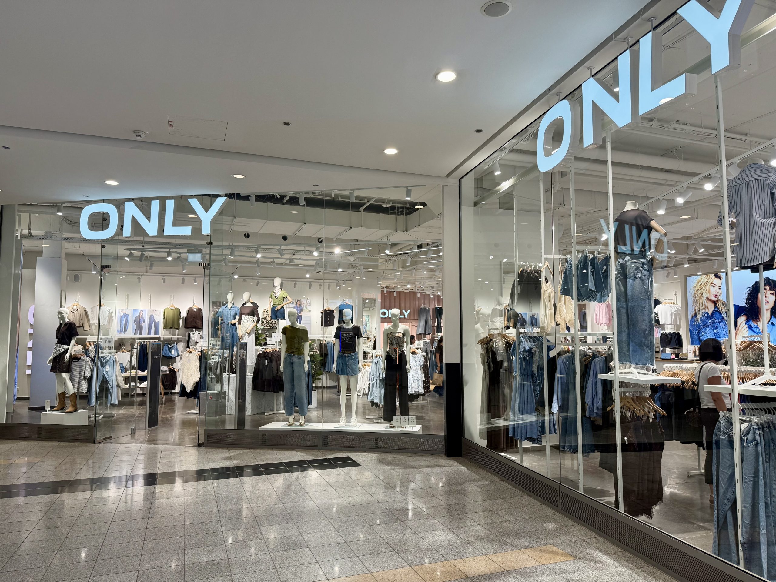 The ONLY shopfront in Belval Plaza, with the pale blue ONLY sign above the entrance and denim skirts, jeans and jackets displayed on mannequins in the window.