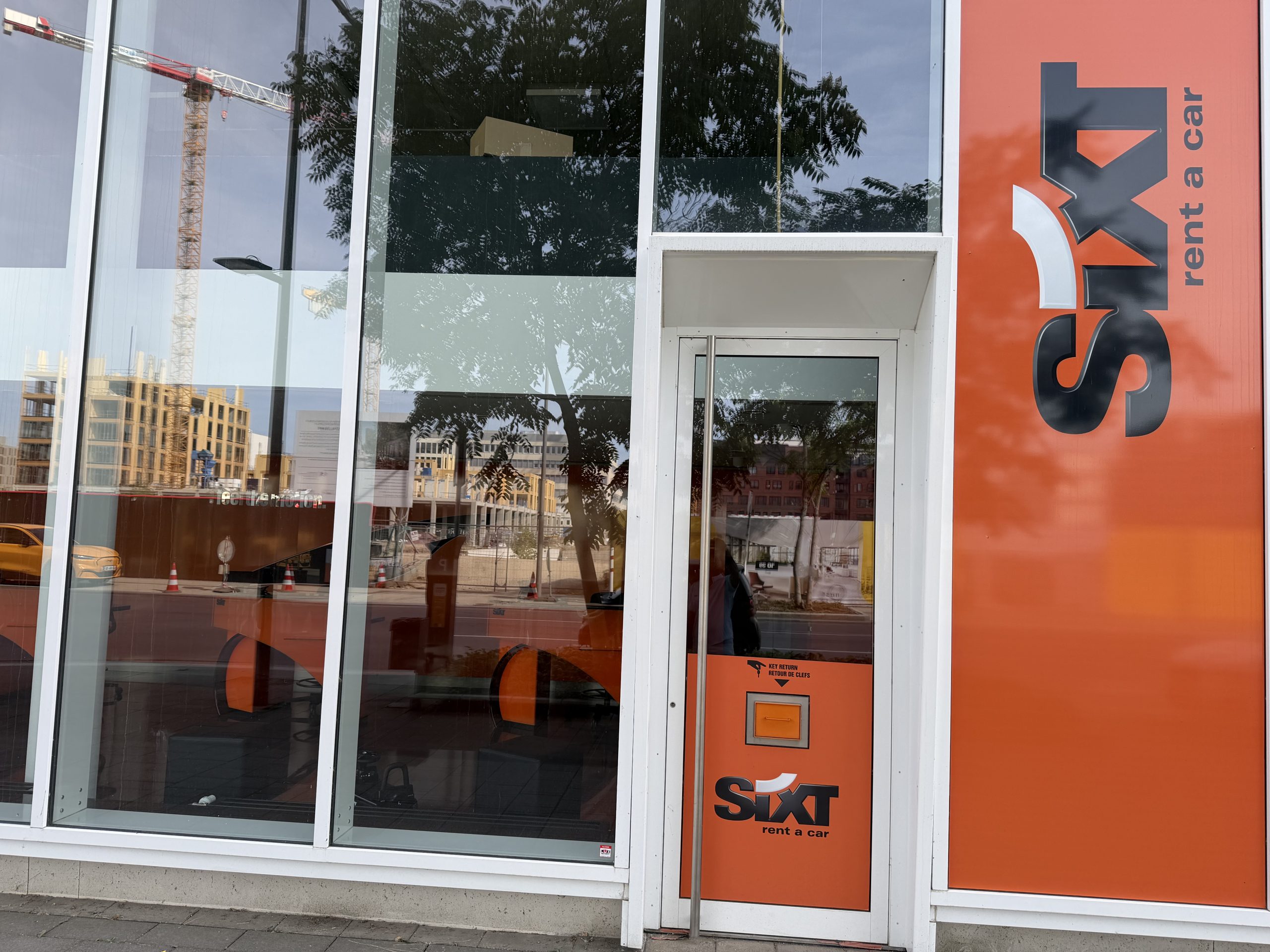 The Sixt car hire branch on boulevard du Jazz in Belval, with the orange Sixt frontage and a key return box beside the door.