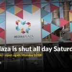 The glass front of Belval Plaza shopping centre with the blast furnace reflected in the windows, overlaid with the words "Belval Plaza is shut all day Saturday. Closes 19:00 Friday, open again Monday 10:00."