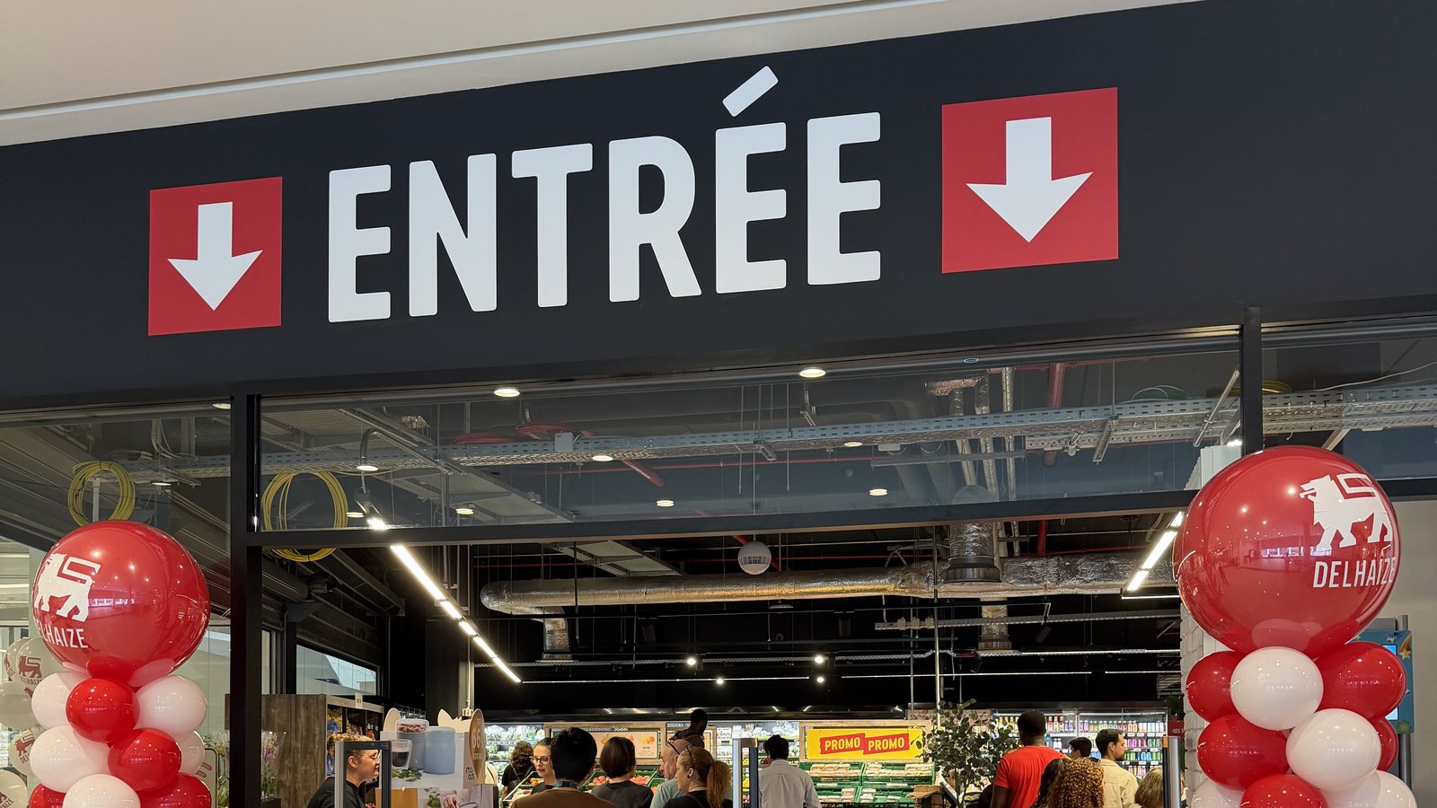 The Entrée sign and balloon columns at Delhaize Belval on the morning it reopened