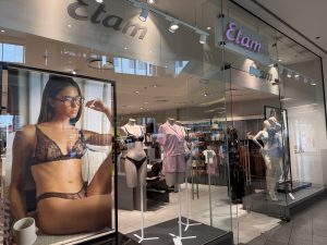 The Etam shopfront in Belval Plaza, with a large window photograph of a model in lace lingerie beside the entrance and mannequins dressed in striped pyjamas and lace tops inside.