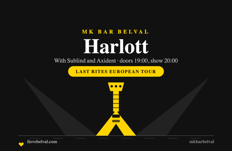 A yellow flying V guitar between two stage beams on black, headed Harlott