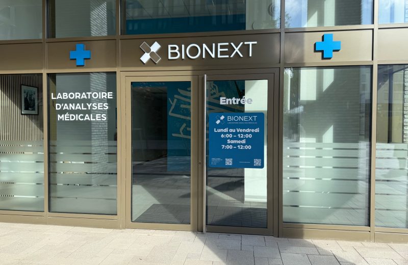 The entrance to the BIONEXT laboratory in Belval, with the opening hours on a blue sign beside the door.