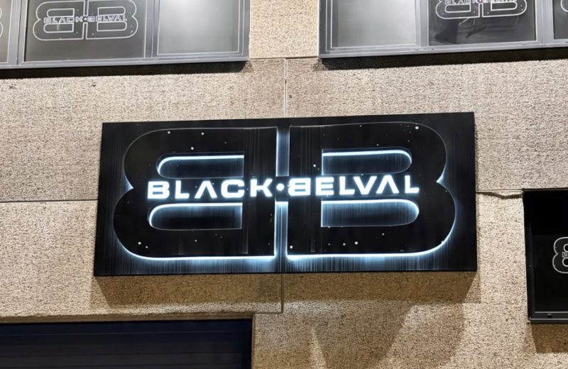 The illuminated Black Belval sign on the front of the club at night, 371 route de Belval