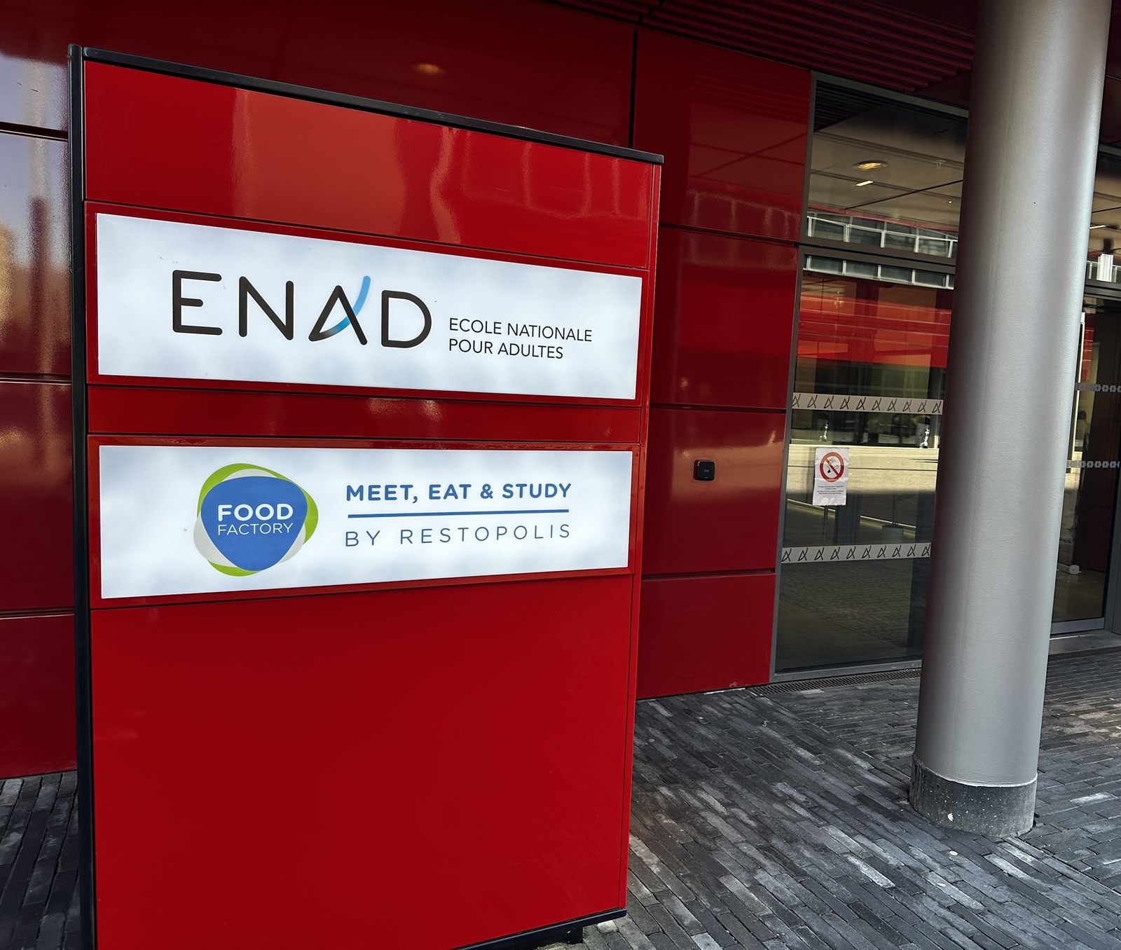 The red totem outside ENAD in Belval carrying the school’s name above the Food Factory logo and the Restopolis strapline.