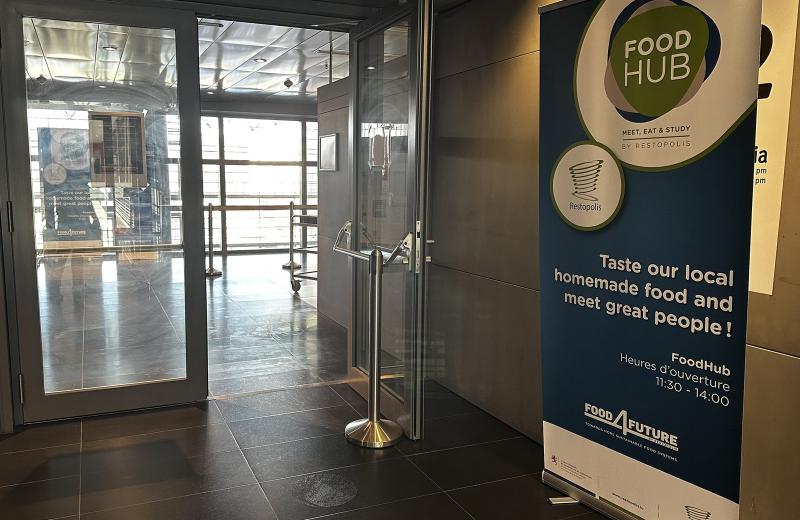 The Food Hub entrance in the Terres Rouges building, a roll-up banner beside the open doors giving the name, the Restopolis mark and the 11:30 to 14:00 opening hours.
