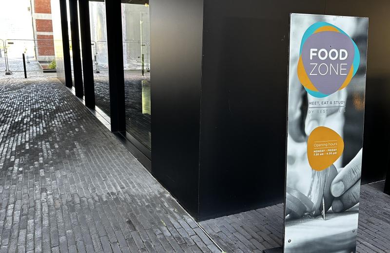 The Food Zone sign on the glazed ground floor of the Maison de l’Innovation on the Belval campus, giving the Restopolis name and the Monday to Friday opening hours.
