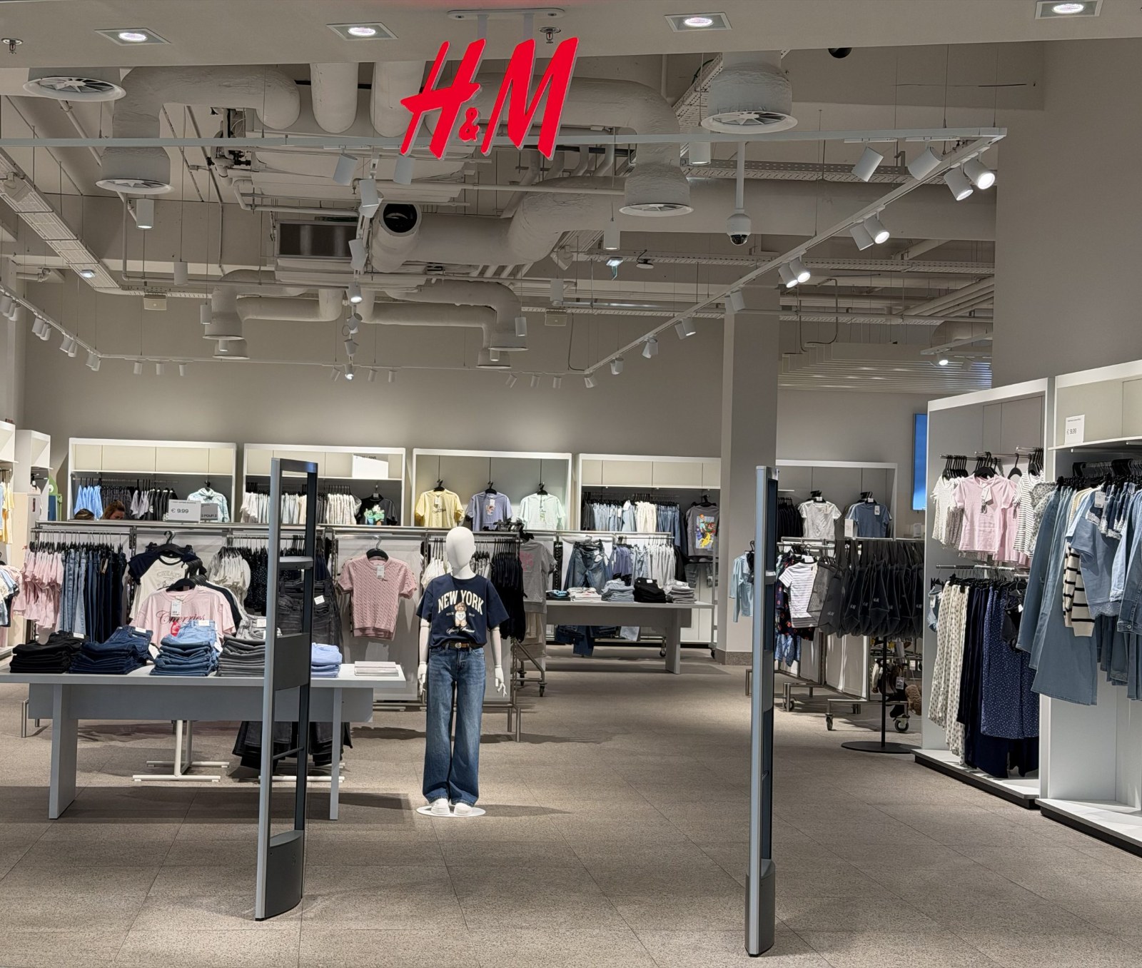 Inside the H&M store in Belval Plaza, with clothing rails under the H&M sign
