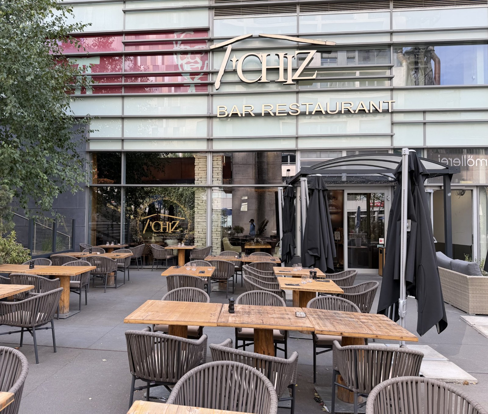 The Le T'Chiz terrace in Belval, with tables set out under the trees