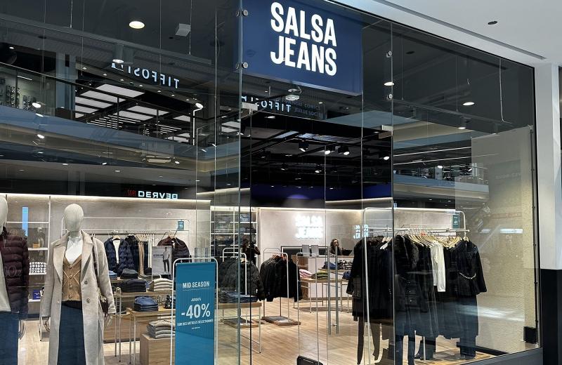 The Salsa Jeans shopfront in Belval Plaza, the navy SALSA JEANS sign above the glass, mannequins in the window and a blue MID SEASON sign inside the open shop.